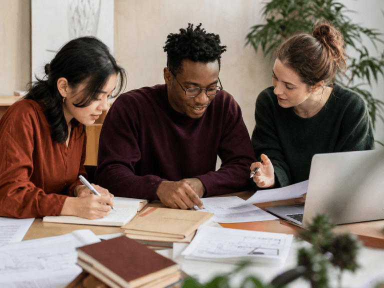 Estudantes revisando juntos a estrutura de um projeto acadêmico